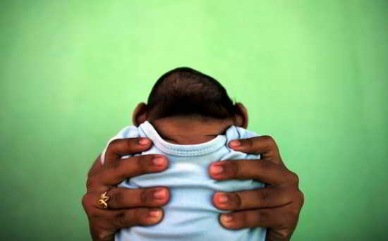 Jackeline, 26 ans, tient son fils qui est né avec microcéphalie à Olinda, près de Recife au Brésil