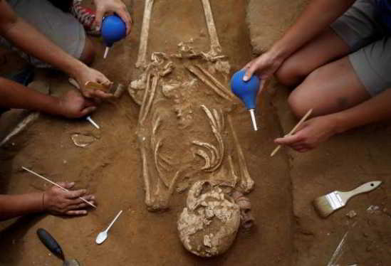 Des étudiants américains en archéologie déterrent un squelette lors des travaux d'excavation du cimetière Philistin au parc national Ashkelon dans le sud d'Israël 28 juin 2016 (REUTERS / Amir Cohen)