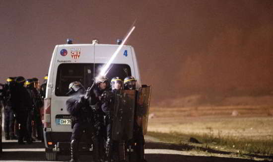 La police a tiré des gaz lacrymogènes quand les migrants jettaient des pierres et s'en prenaient aux camions